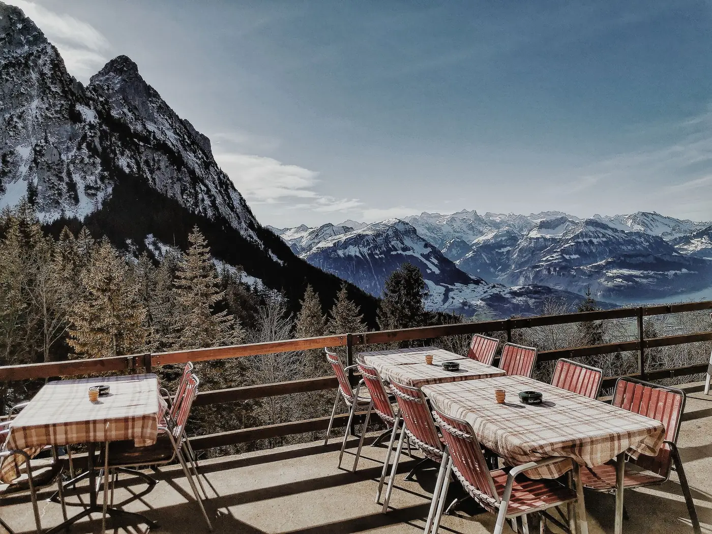 Buitenterras van een restaurant met uitzicht op besneeuwde bergen