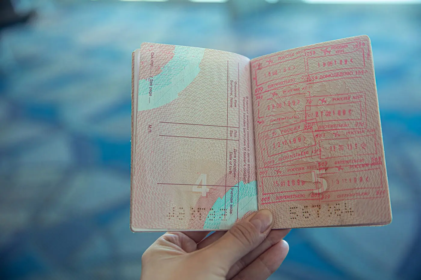 Iemand houdt een geopend paspoort vast in een luchthaven