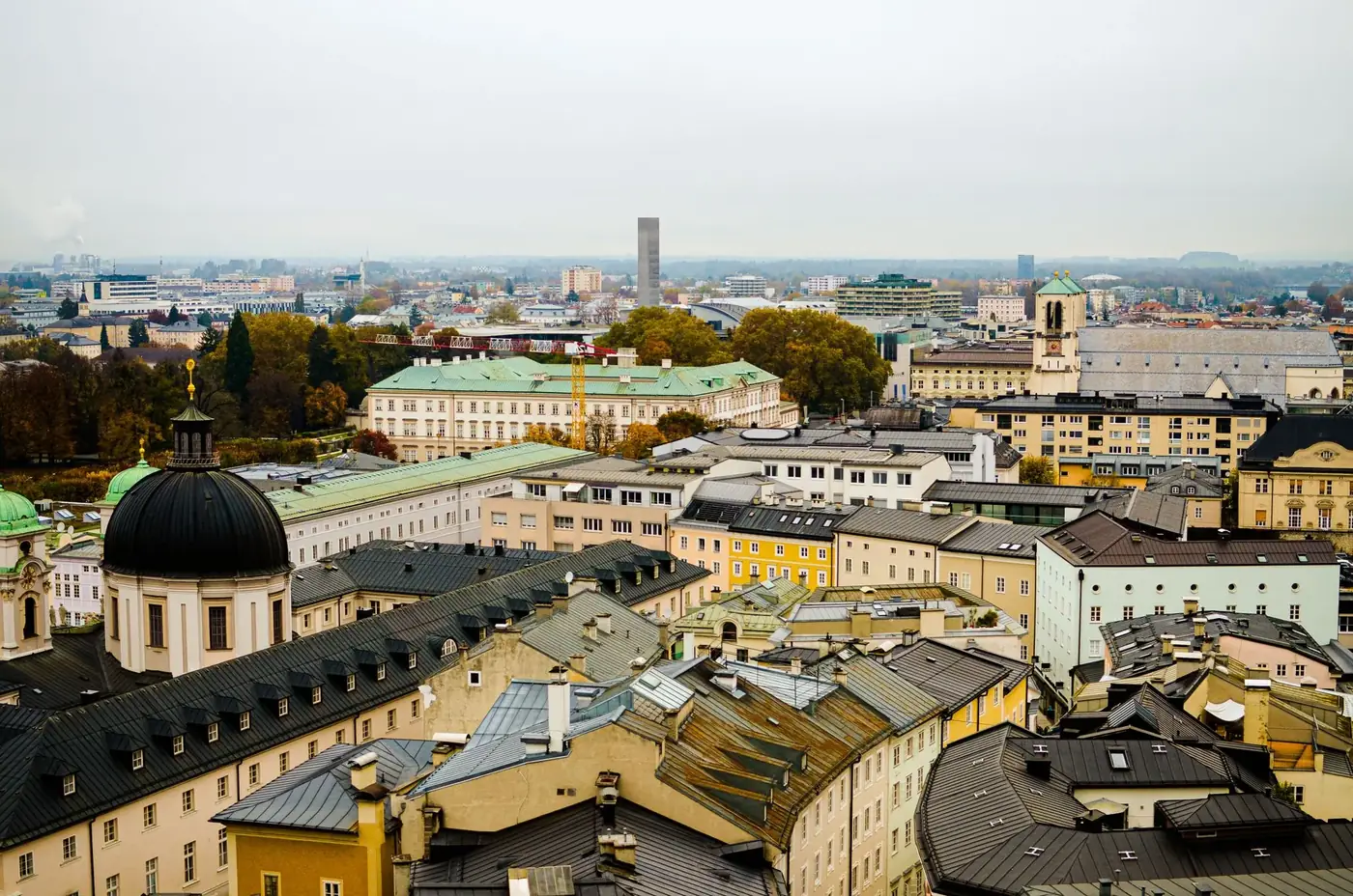 Aerial view of Salzburg showcasing historic buildings and distant cityscape.