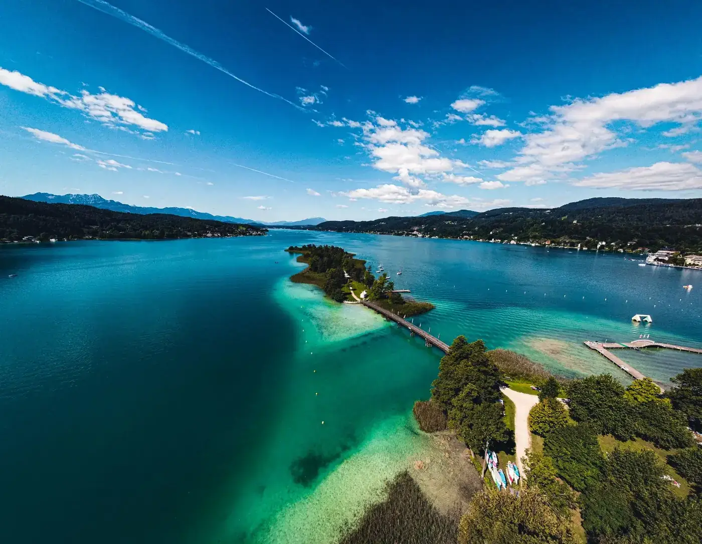 Stunning aerial view of Lake Wörthersee, showcasing vibrant waters and scenic landscapes in Pörtschach, Austria.
