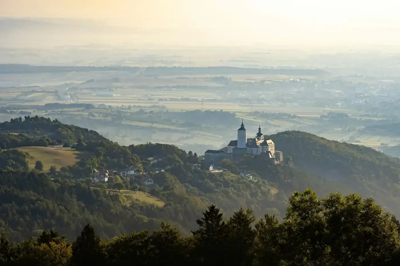 Stunning landscape of a monastery amidst rolling hills in Steiermark, Austria at dawn.