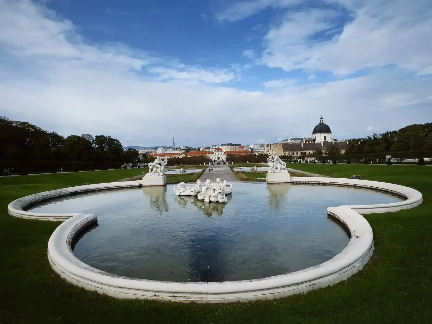 Elegant baroque fountain with sculptures at Upper Belvedere Palace, Vienna under a vibrant sky.