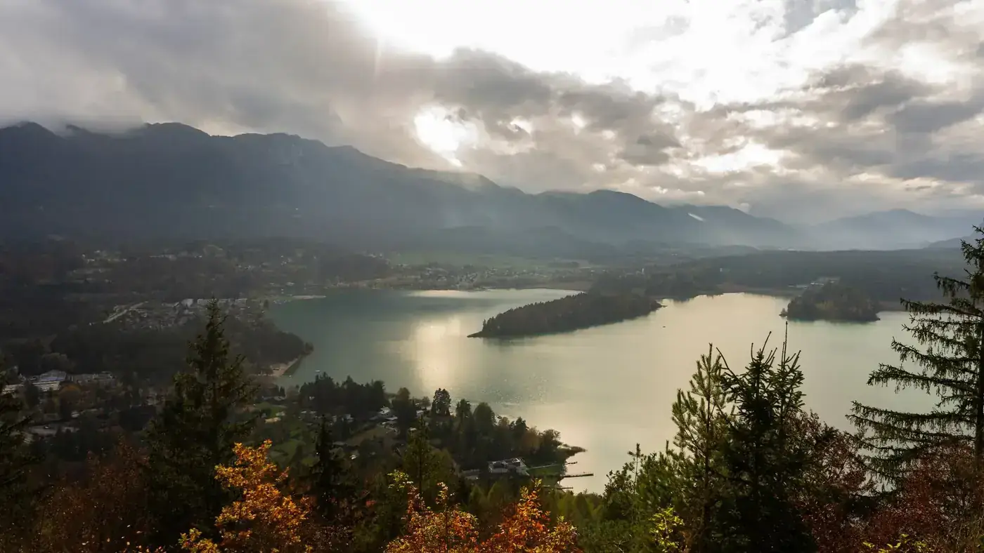 Beautiful aerial landscape of a lake surrounded by mountains in Villach, Austria.