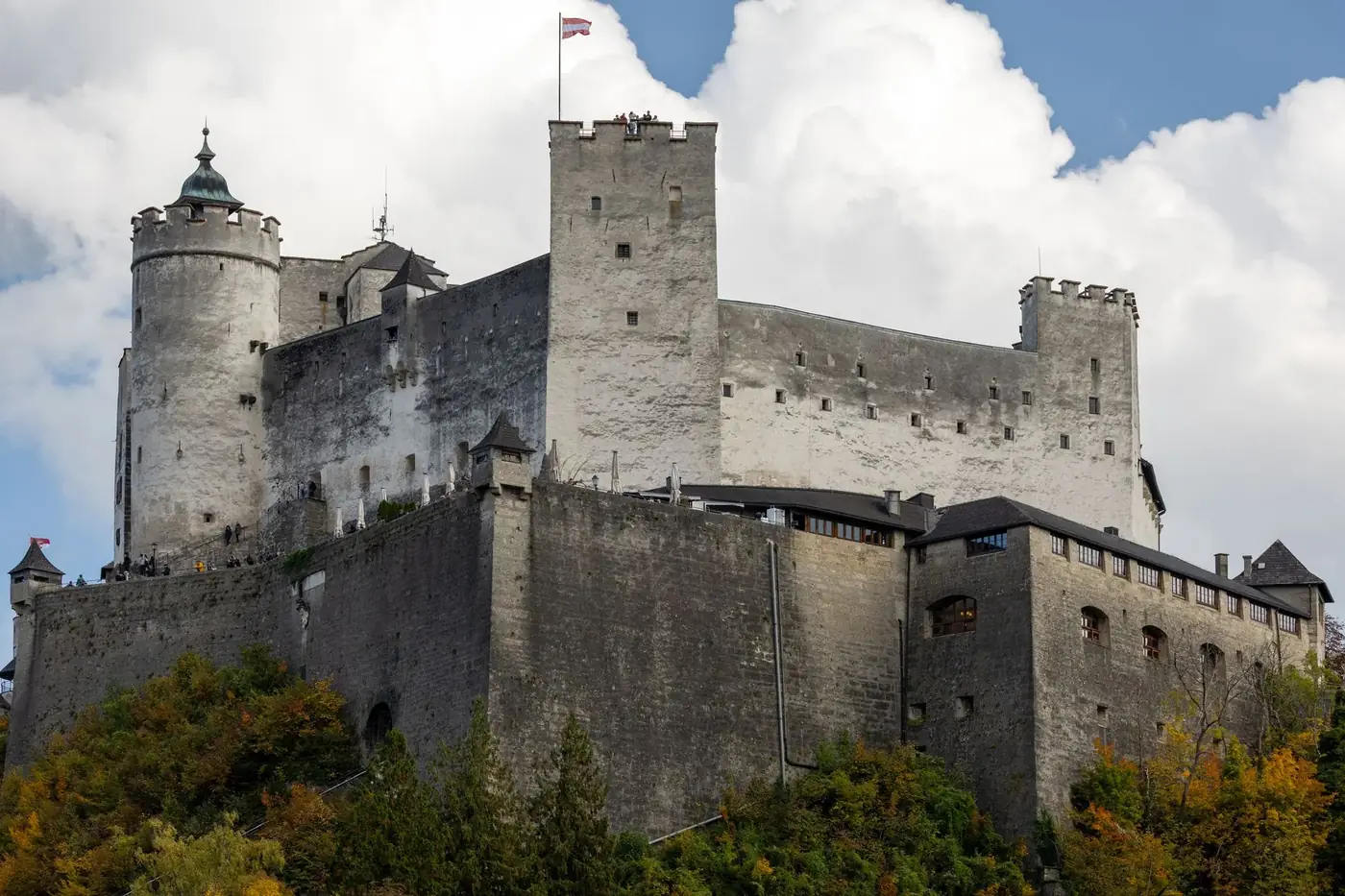 Majestic Hohensalzburg Castle in Salzburg, surrounded by colorful autumn foliage.