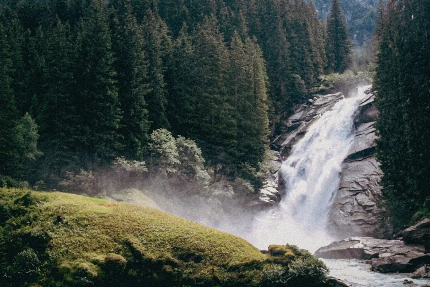 Breathtaking view of a waterfall cascading through lush forest in Salzburg, Austria.