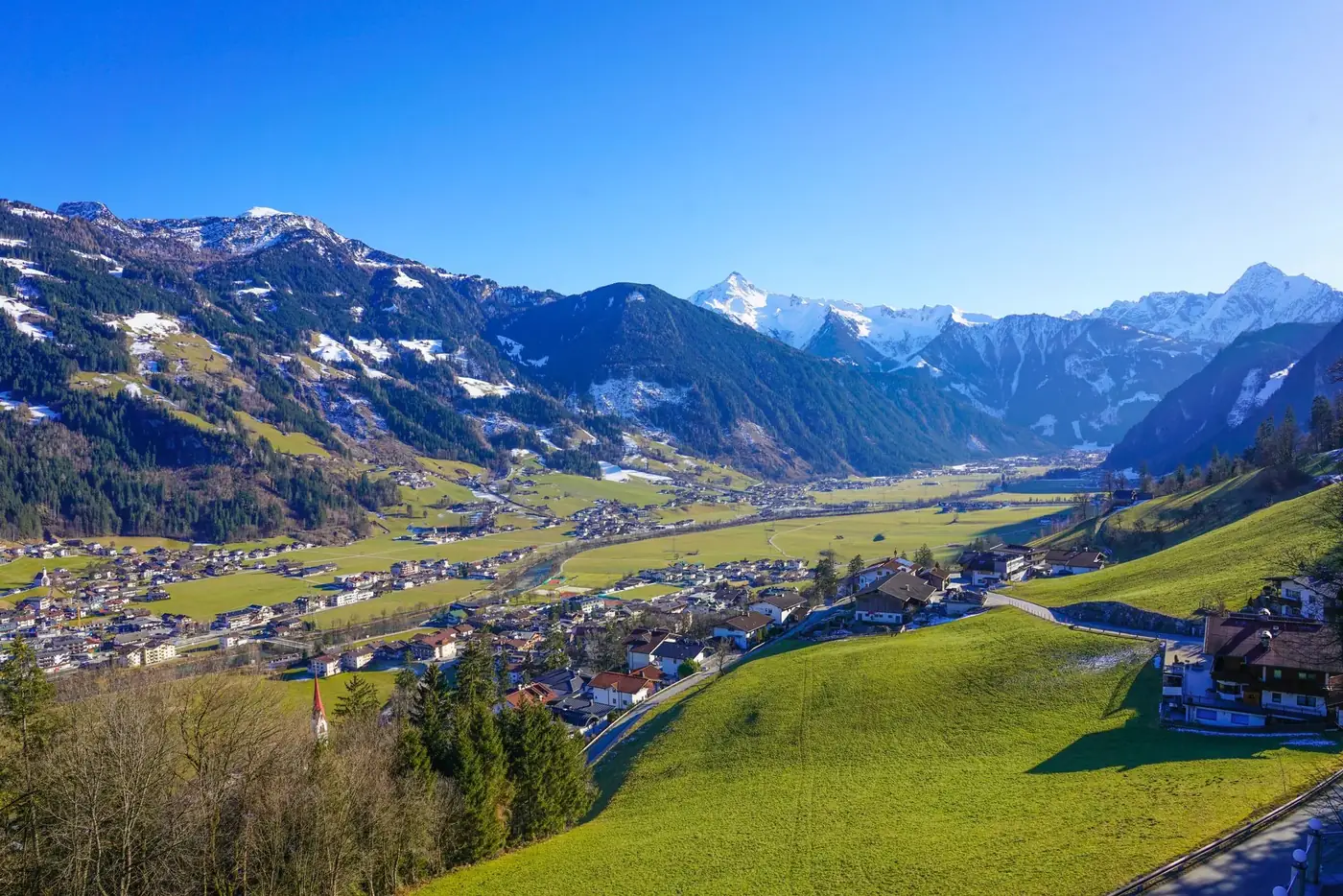 Breathtaking panorama of Zillertal Valley in spring with snow-capped mountains.