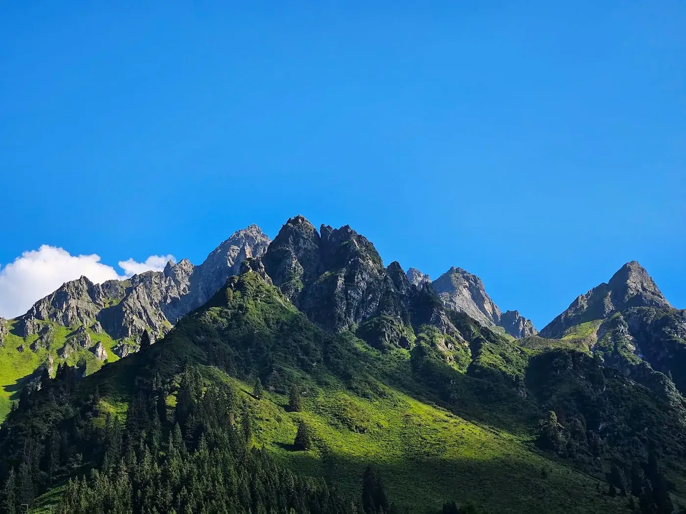 Breathtaking view of Vorarlberg's Rätikon mountains under clear summer skies.
