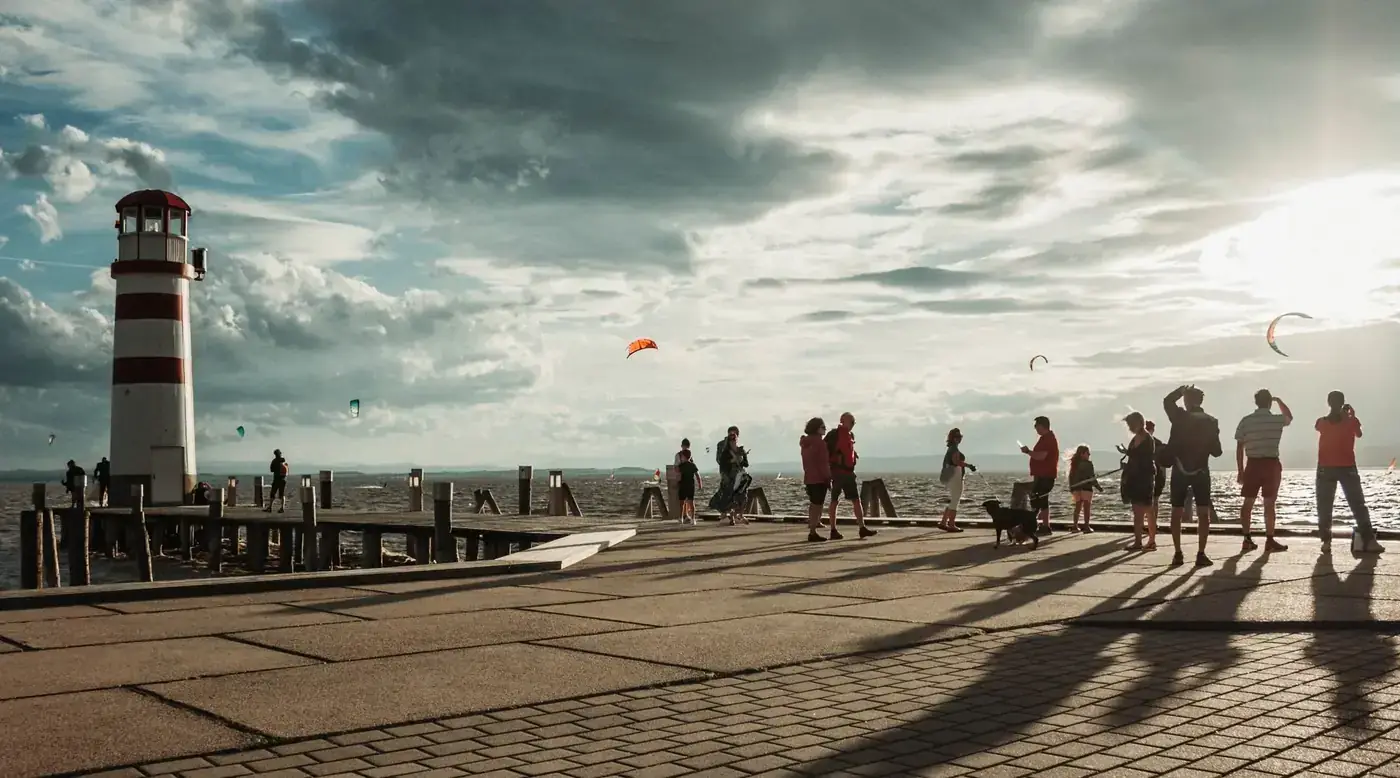 People enjoying kitesurfing by the lighthouse at Lake Neusiedl, Austria.