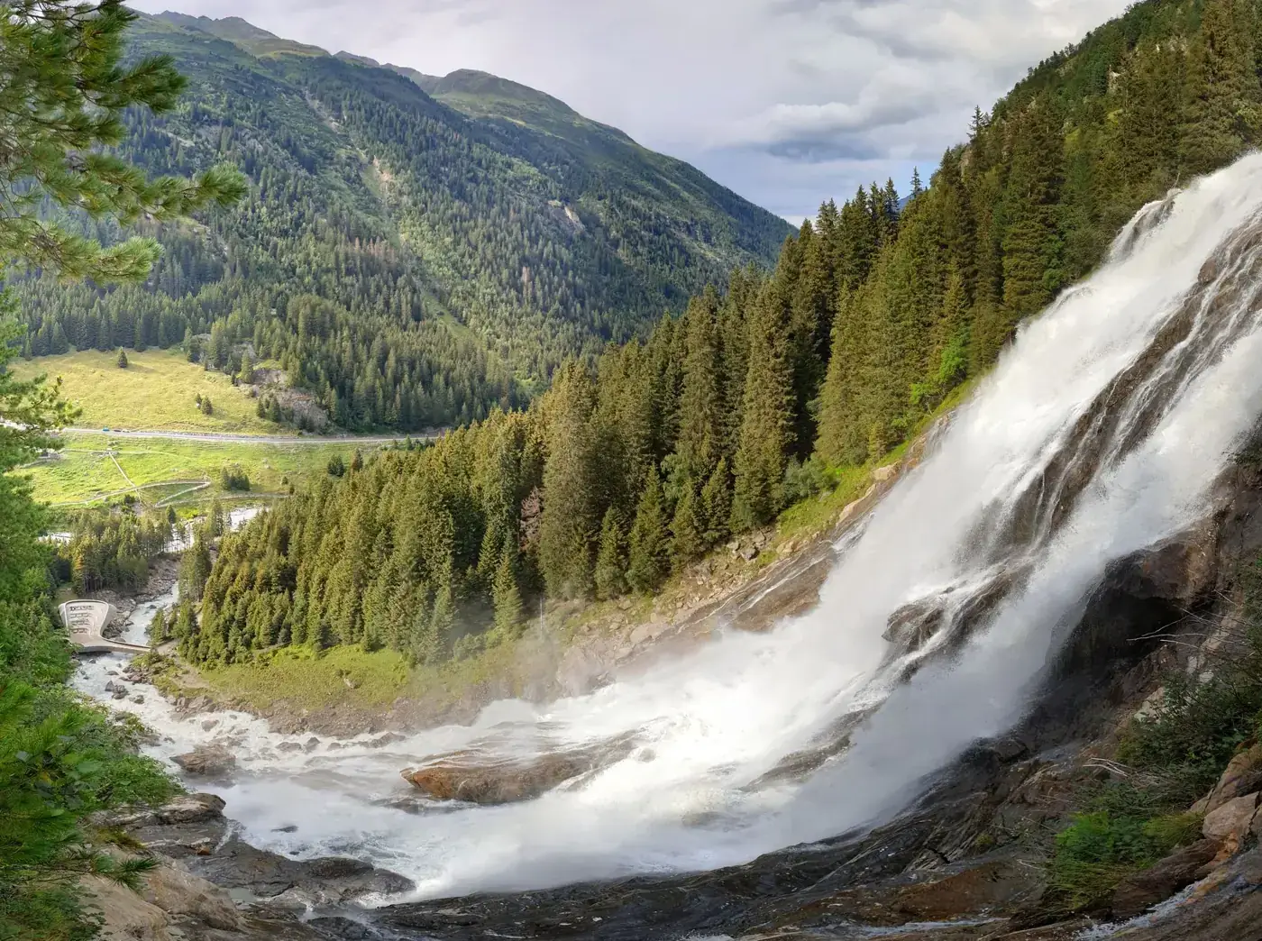 Spectacular view of Stuibenfall waterfall cascading through lush green forest in Tirol, Austria.