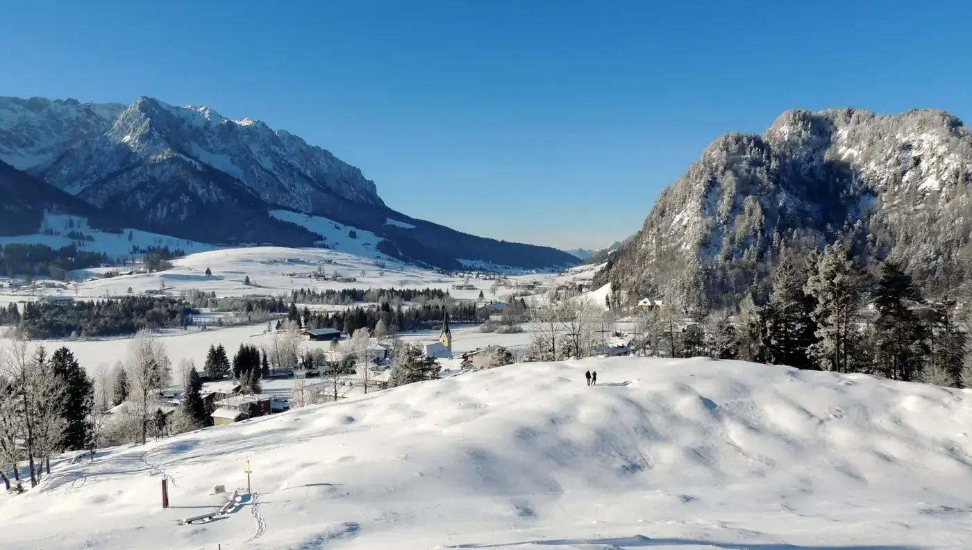 Picturesque winter view of snow-covered Walchsee, Tirol with majestic mountains.