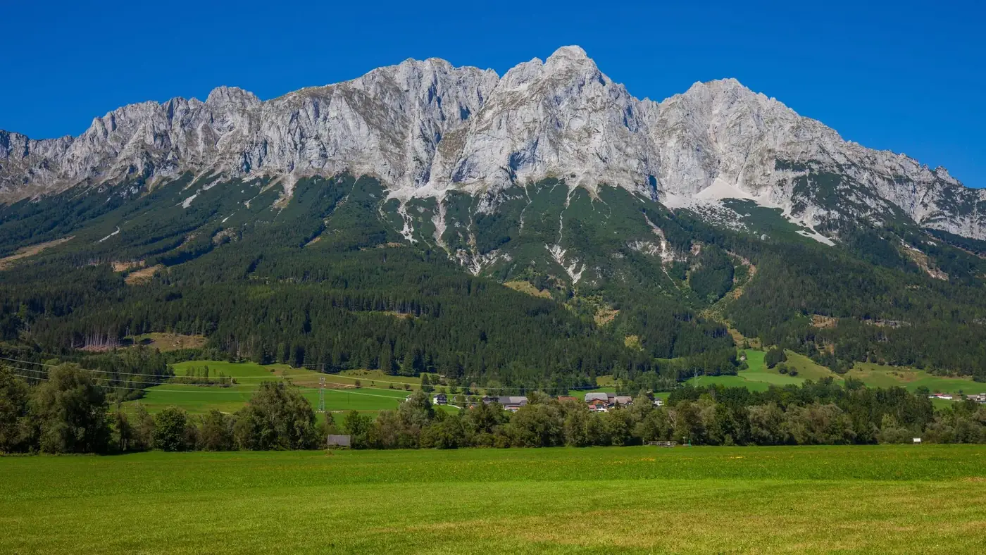Breathtaking landscape of the Dachstein Mountains in Styria, Austria, showcasing lush green fields.