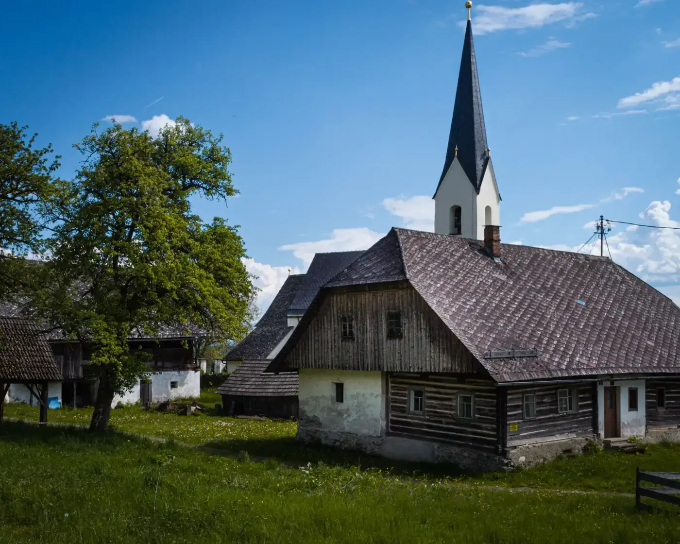 Idyllic village scene with a traditional church in Klagenfurt, capturing rustic charm and serene landscape.
