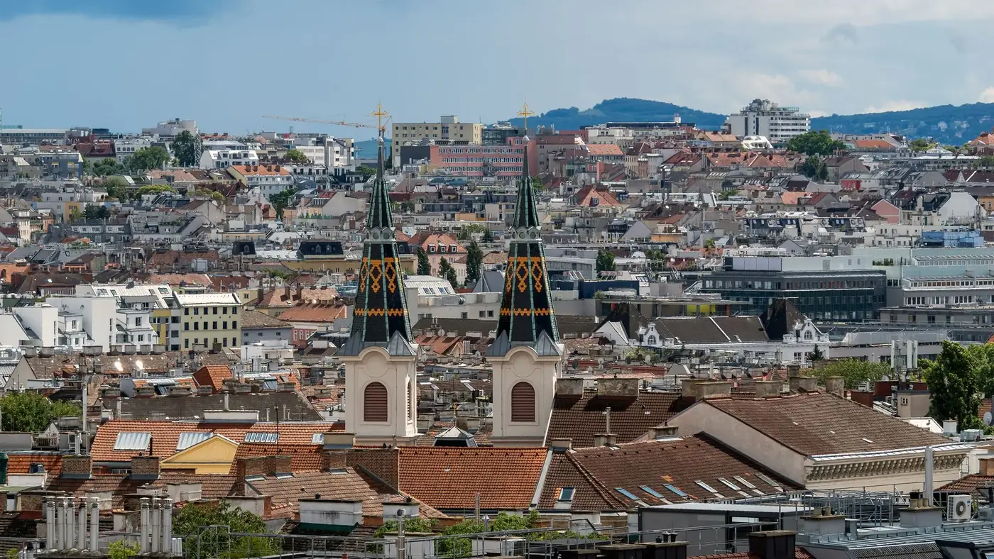 Skyline of Vienna, Austria with historical architecture and two church spires in view.