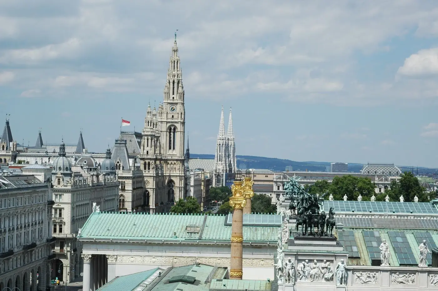 Aerial view of Vienna showcasing the town hall, Votivkirche, and architectural landmarks.