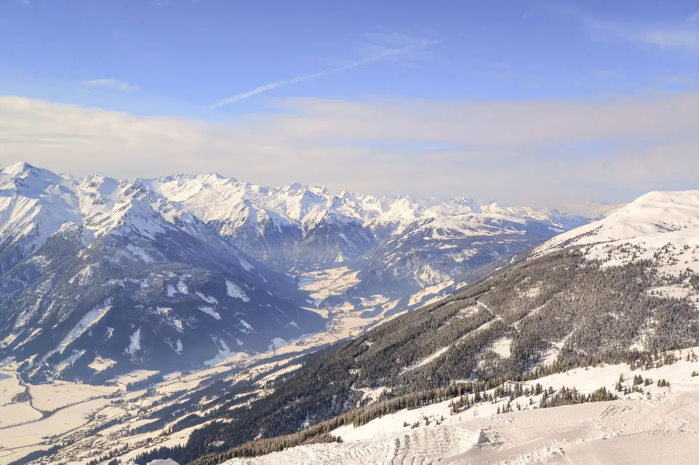 Breathtaking view of snow-capped mountains under a clear blue sky in winter.