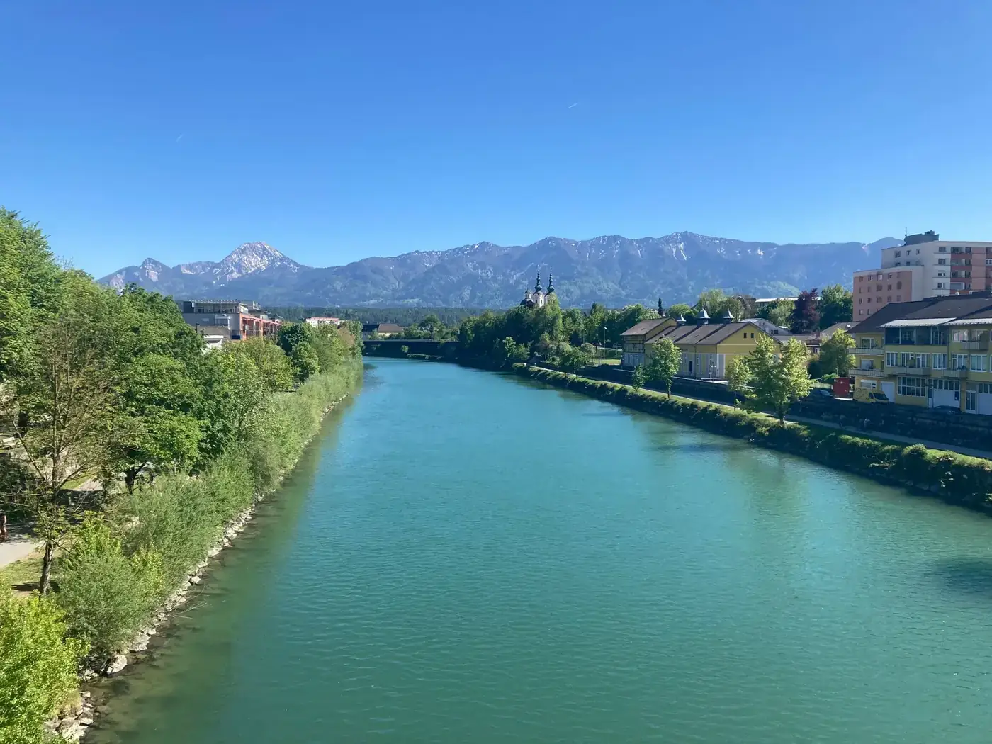 Beautiful view of a river with mountains in Villach, Austria.