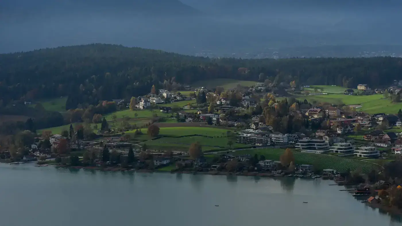 A picturesque aerial view of Villach, Austria showcasing autumn landscapes and serene waters.