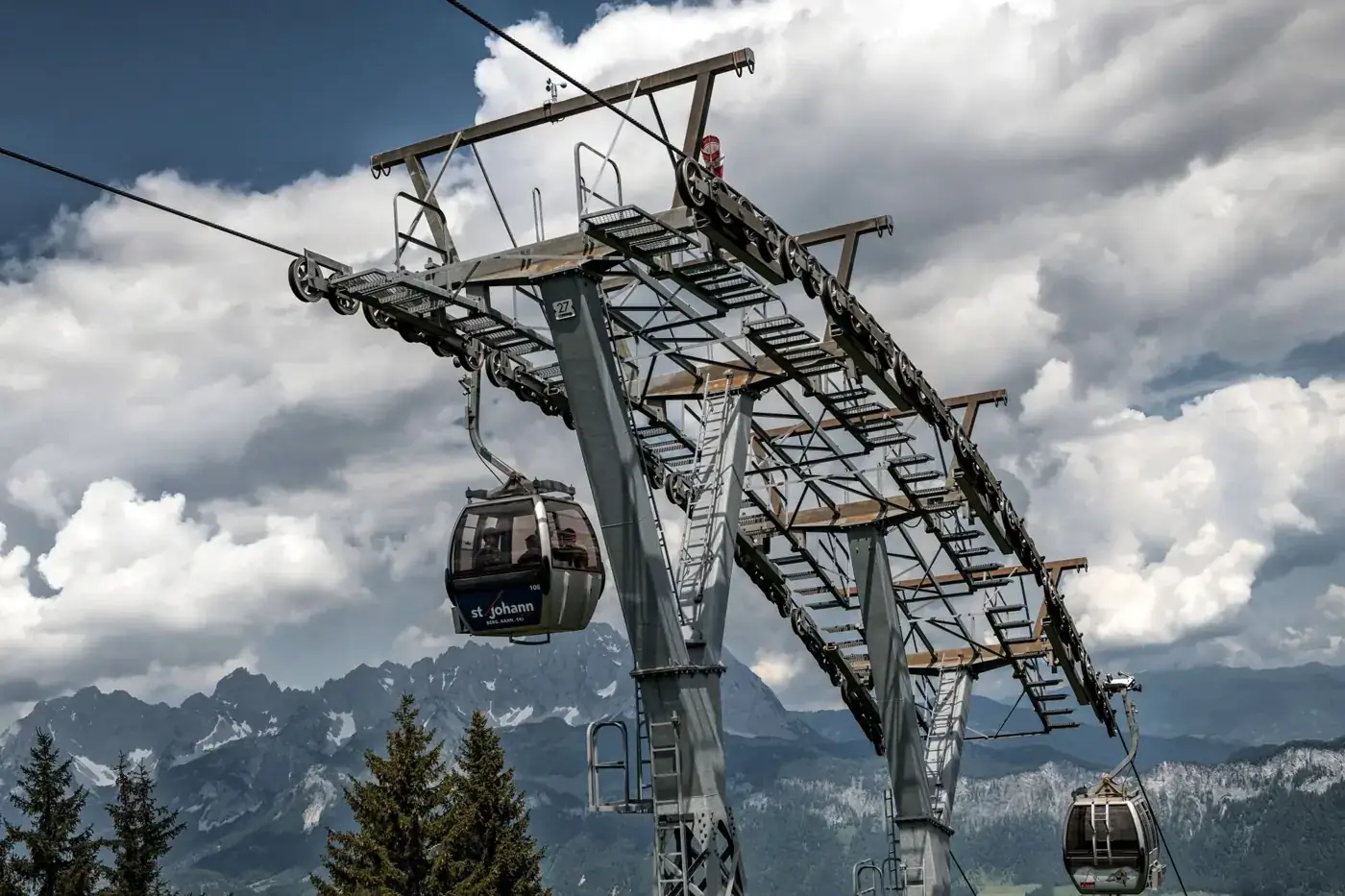 Cable cars ascending over mountains in Kufstein, Tirol, offering stunning alpine views.
