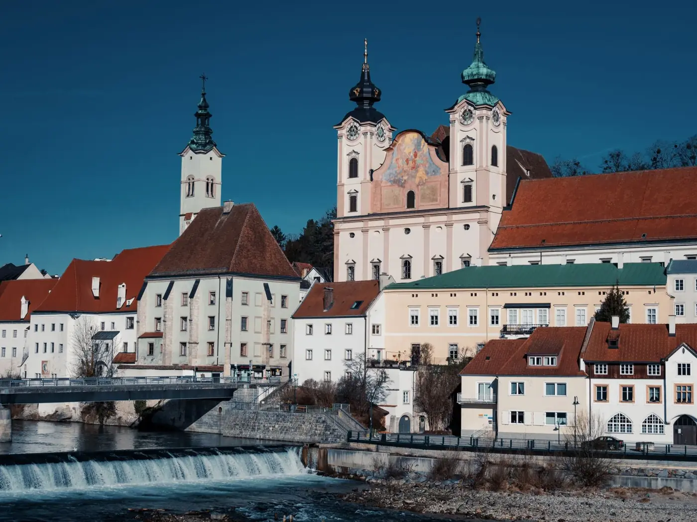Scenic view of St. Michael's Church and river in Steyr, Austria.