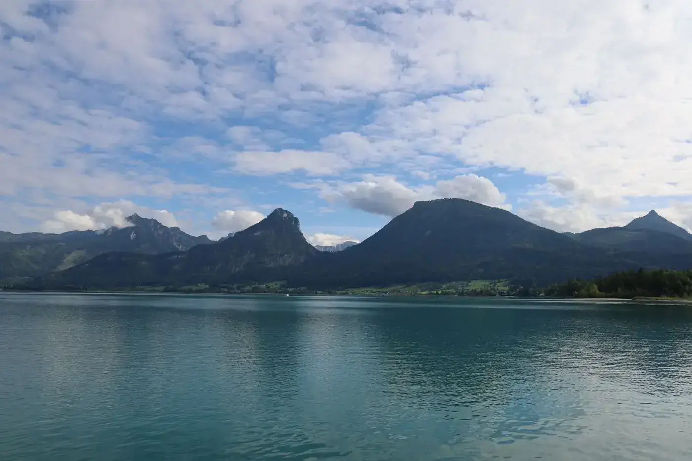 Beautiful view of an alpine lake with mountains in Austria under a vibrant sky.